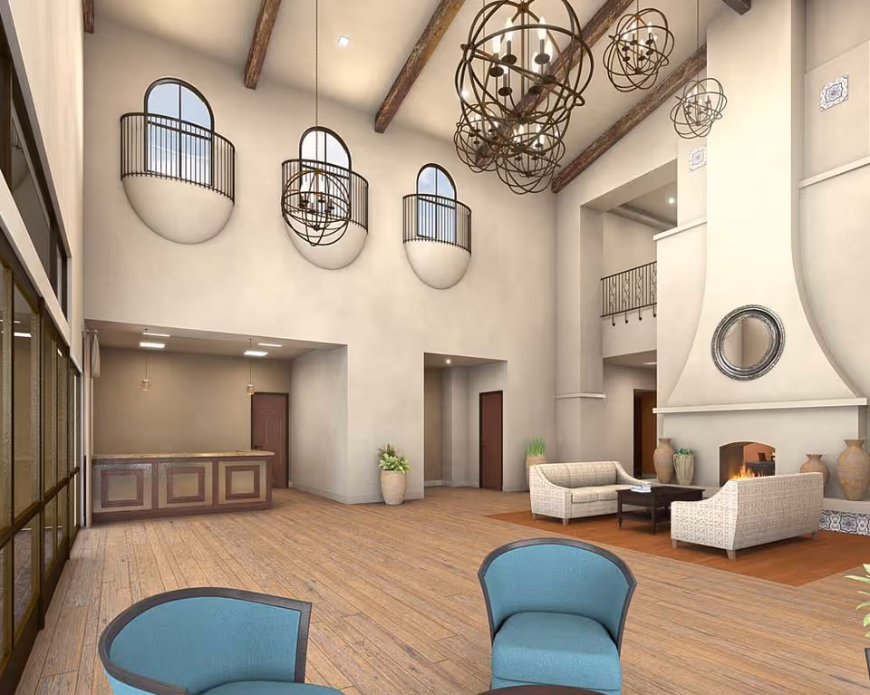 Spacious high-ceilinged senior living lobby with hanging chandeliers, arched balcony windows, a reception desk, fireplace and seating area.