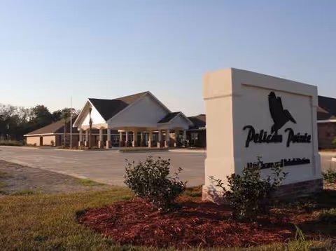 Pelican Pointe Healthcare entrance with a sign and manicured landscaping.