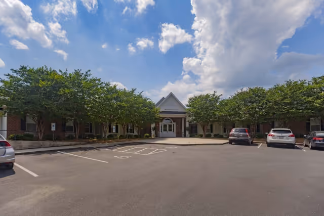 Front view of Rock Hill Post Acute Care Center with landscaped trees and parking area.