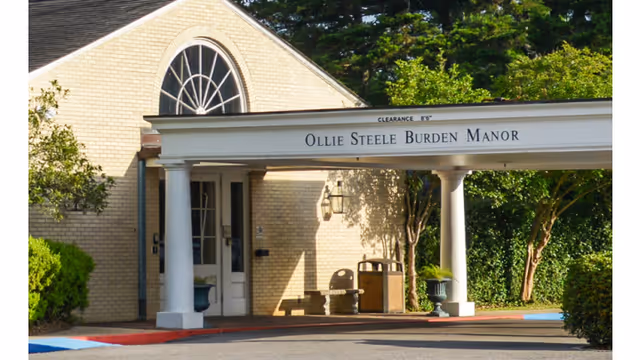 The covered main entrance and portico of Ollie Steele Burden Manor Nursing Facility with columns and signage.