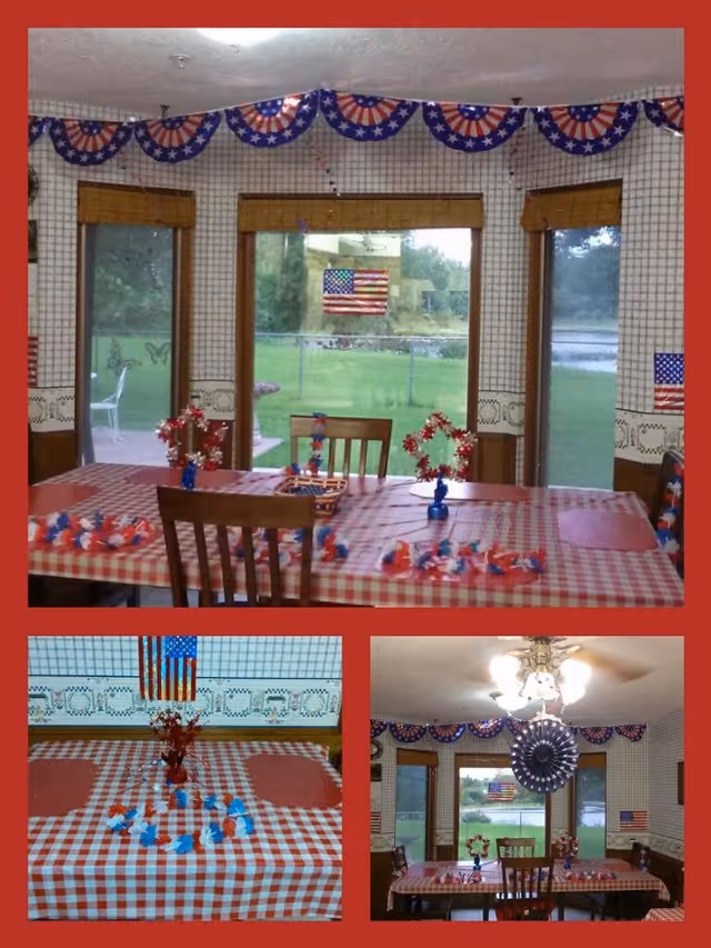 Three images showing a dining room decorated with patriotic American flag-themed decorations. The room has a checkered red and white tablecloth on the dining table, with red, white, and blue decorative items arranged on top. The walls have a patterned wallpaper and windows with bamboo blinds, showing a green outdoor view. The ceiling has a light fixture with a fan and hanging decorations.