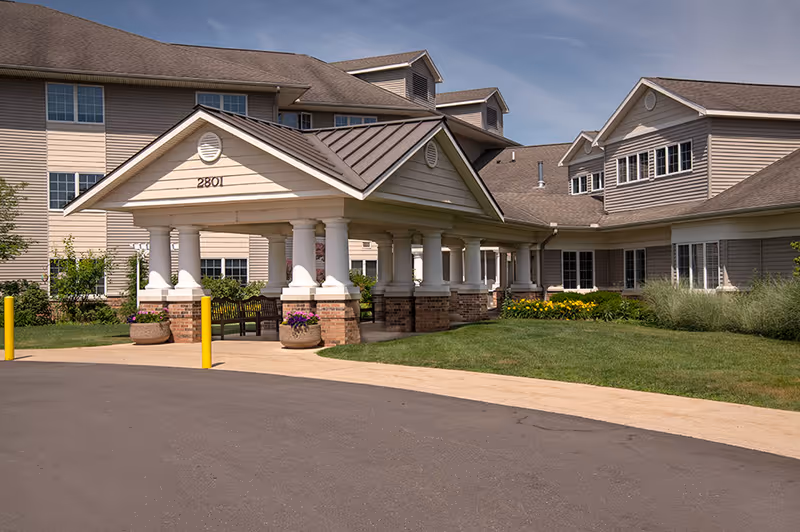 Senior living facility Vista Grande Villa exterior with a covered entrance and landscaped front yard.