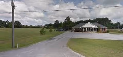 Exterior view of Thomson Health and Rehabilitation facility with circular driveway and green lawn