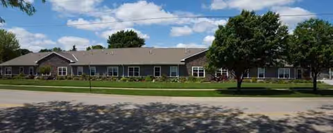Exterior view of Westhaven Community: a single-story facility with windows, trees, and a road.