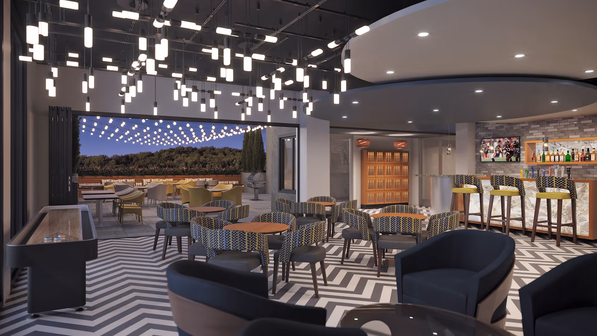 A modern indoor lounge and bar area with patterned chairs and tables, a bar with stools and various bottles on shelves, a television mounted on the wall, and a shuffleboard table. The space opens to an outdoor patio with string lights overhead, additional seating, and a grill, surrounded by greenery and trees in the background.