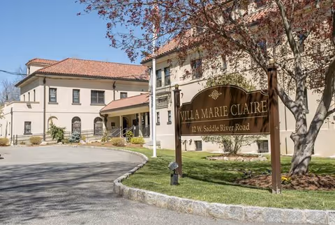 Exterior view of Villa Marie Claire with sign and entrance.