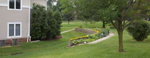 Exterior view of Buchanan County Health Center with lawn, trees, and landscaped garden.