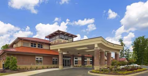 Front view of a brick senior living center with a covered entrance.