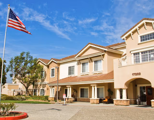 Front exterior view of Bayshire Yorba Linda senior living facility with flagpole.