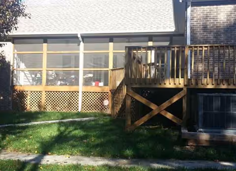 Backyard view of Gracie Strudivant Care Home with wooden deck and screened porch.
