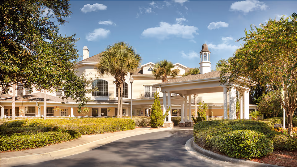 Sunny exterior view of a senior living facility with entrance canopy.