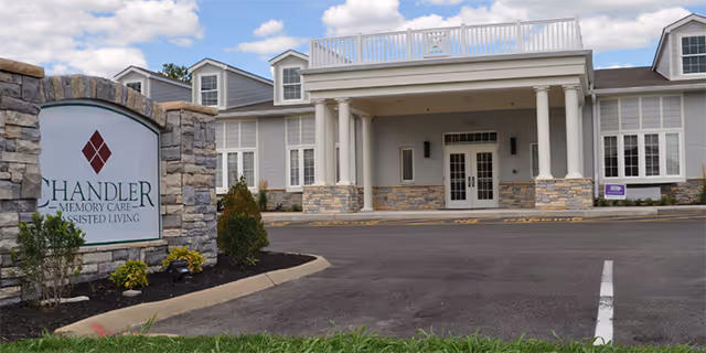 Exterior view of Chandler Memory Care Assisted Living building with entrance and parking.