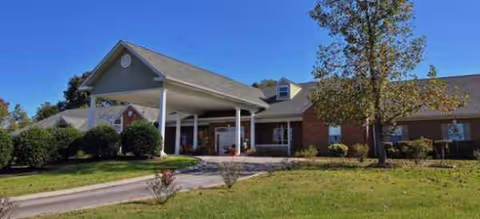 Single-story brick senior living facility with a covered entry and manicured lawn.