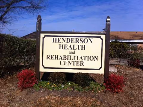 Front view of Henderson Health and Rehabilitation Center sign with shrubs and mulch.