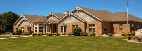 Exterior view of Angels Touch Assisted Living building with brick facade and landscaped lawn.