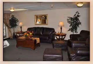 Cozy lounge with leather sofas, coffee tables, lamps, and potted plants.