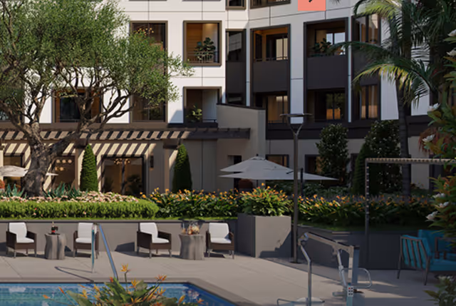 Outdoor patio area at a senior living facility with a swimming pool in the foreground, several chairs and tables arranged around the pool, lush greenery and plants, and a multi-story building with balconies in the background.
