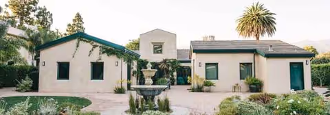 Cream exterior buildings surround a central fountain in a landscaped courtyard.