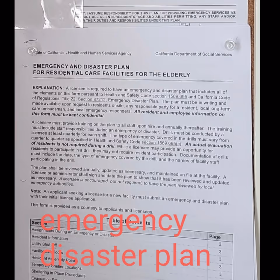 A printed emergency and disaster plan for residential care facilities for the elderly, posted on a bulletin board. The document includes explanations about training, drills, and plan review requirements. Large red text over the document reads 'emergency disaster plan'.