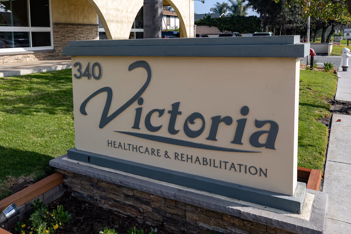 Outdoor entrance sign reading "340 Victoria Healthcare & Rehabilitation" on a landscaped lawn in front of a building.