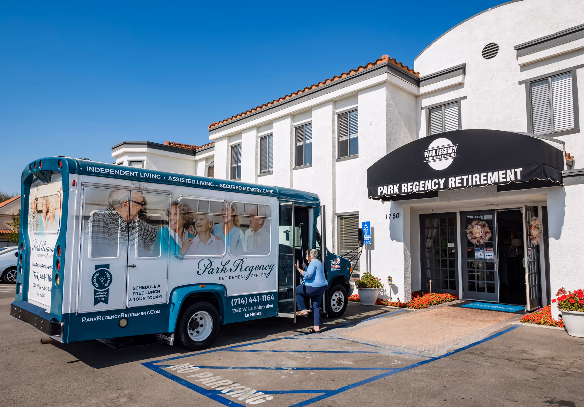 A Park Regency Retirement Center shuttle parked outside the facility entrance as a woman boards under an awning reading "Park Regency Retirement."