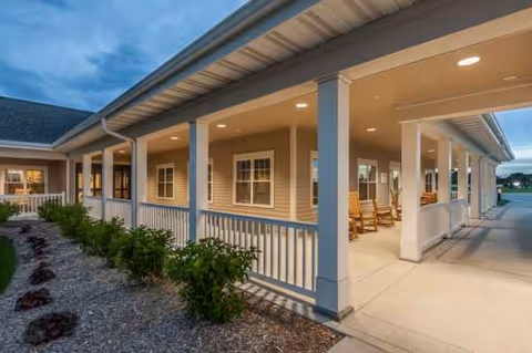 Exterior view of Brookestone Acres featuring a covered front porch and rocking chairs.
