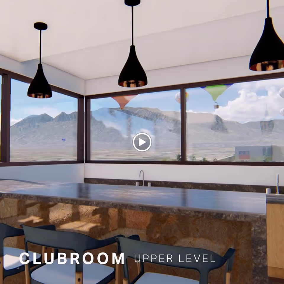 Interior view of a clubroom upper level with a stone countertop bar, modern black pendant lights hanging from the ceiling, and large windows showing a mountainous landscape with hot air balloons in the sky.