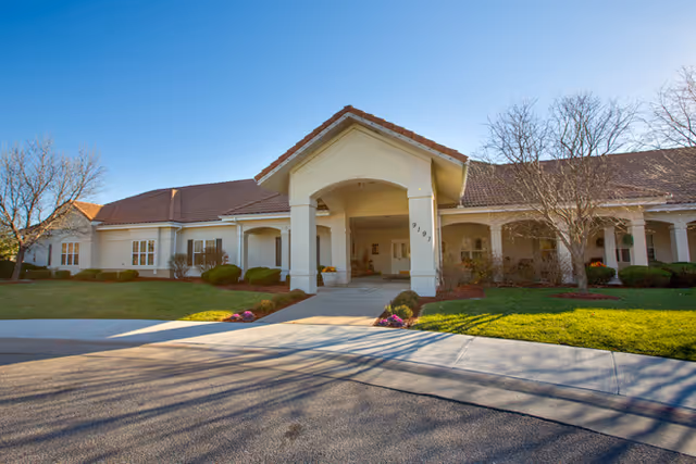 Exterior view of Brookdale East Wichita entrance with a covered portico and landscaping.