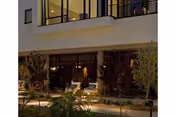 Exterior view of Westminster Village building with glass doors and surrounding plants.