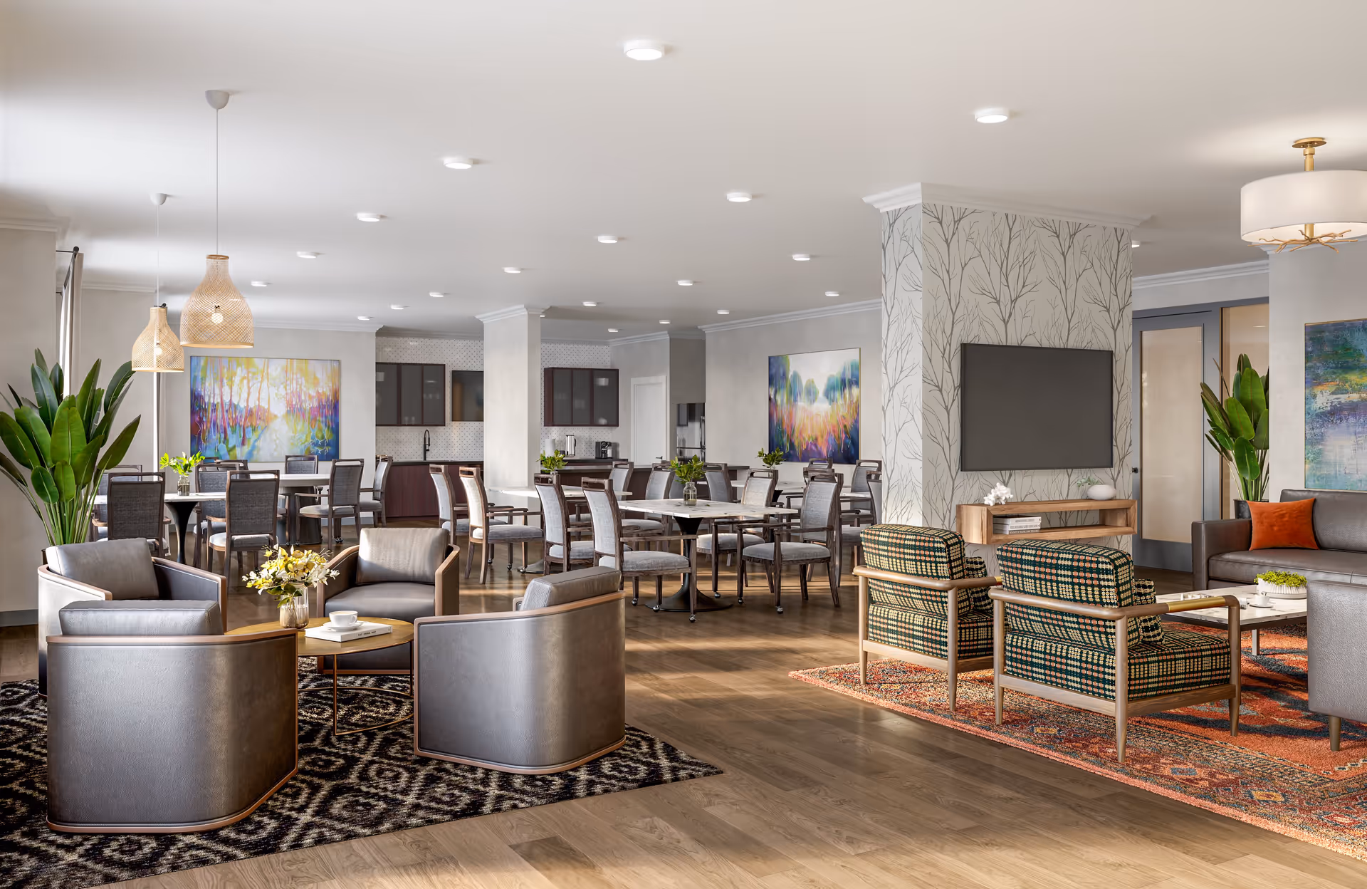 Open communal senior living interior with lounge seating, dining tables, a wall-mounted TV, and colorful artwork.