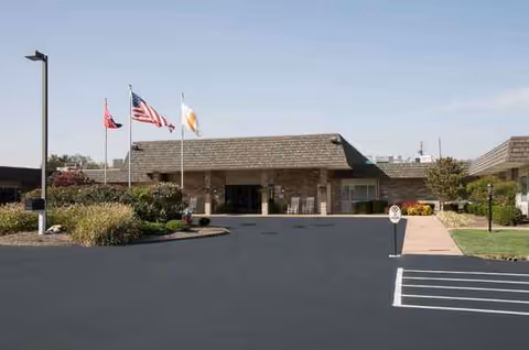 Front view of a senior care facility entrance with flags