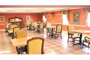 A spacious dining room with multiple tables and chairs arranged neatly. The room has peach-colored walls with white trim, large windows with curtains allowing natural light to enter, and framed artwork on the walls. The floor has a checkered pattern in shades of pink and white.