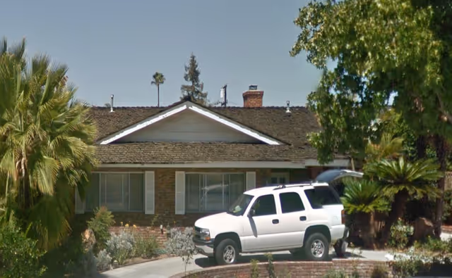 Single-story senior care facility exterior with a white SUV parked near the entrance.