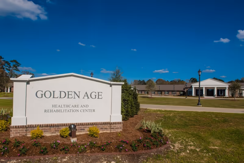 Outdoor view of the Golden Age Healthcare and Rehabilitation Center sign with the facility building in the background under a clear blue sky.