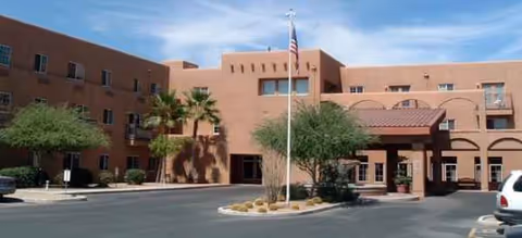 Front view of Brookdale Apache Junction senior living facility with entrance and flagpole.
