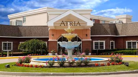 Atria Cranford senior living facility entrance with a fountain and landscaped grounds.