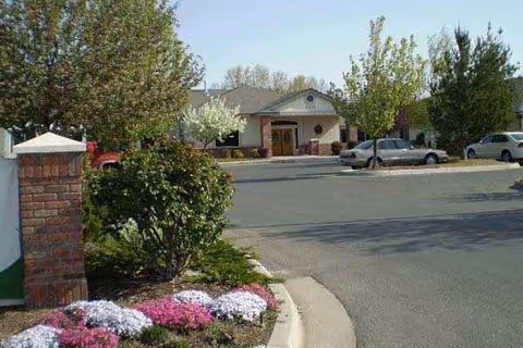 Front view of Overland Court Senior Living entrance with cars and landscaping.