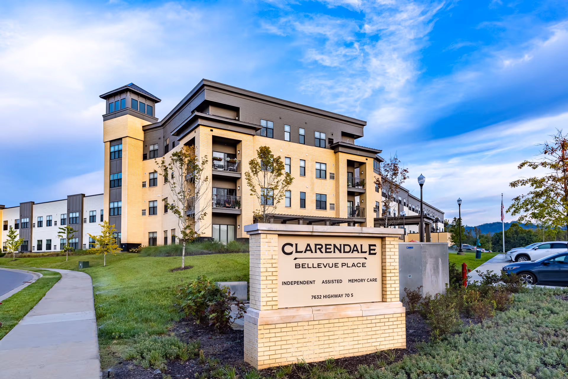 Exterior view of the Clarendale at Bellevue Place senior living building with the facility sign in the foreground.