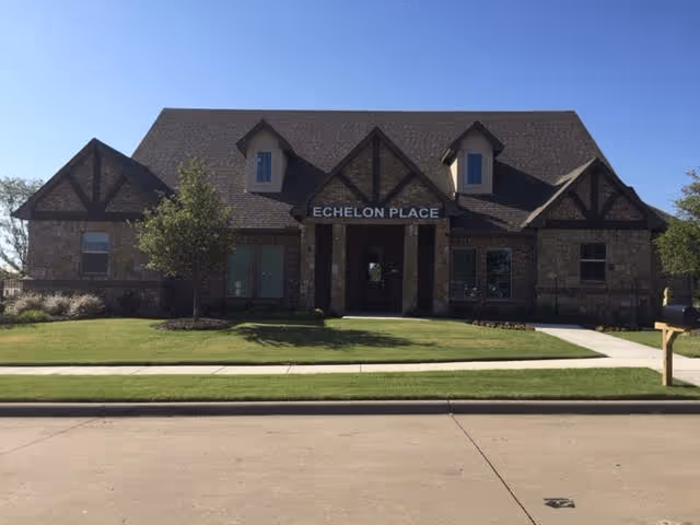 Exterior view of Echelon Place Assisted Living facility showcasing stone architecture and landscaping.