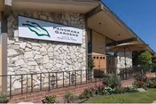 Exterior view of Panorama Gardens Nursing & Rehabilitation Center with stone facade and sign.