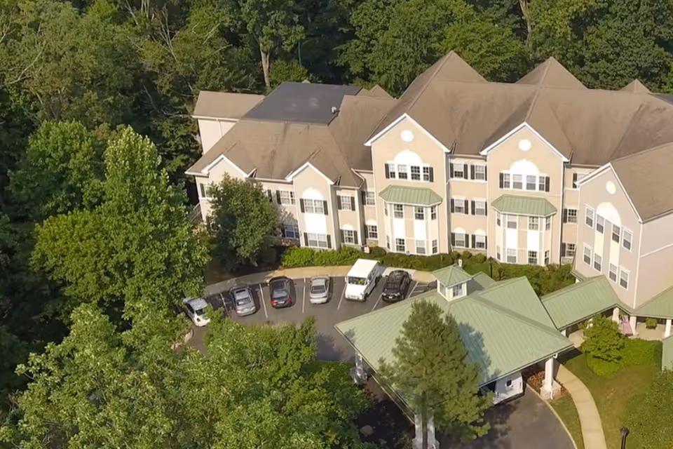 Aerial view of Brandywine Living at Serenade at Princeton exterior with parking and trees.
