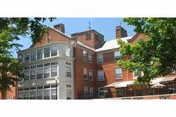 Brick facade of an assisted living building with white trim and trees.