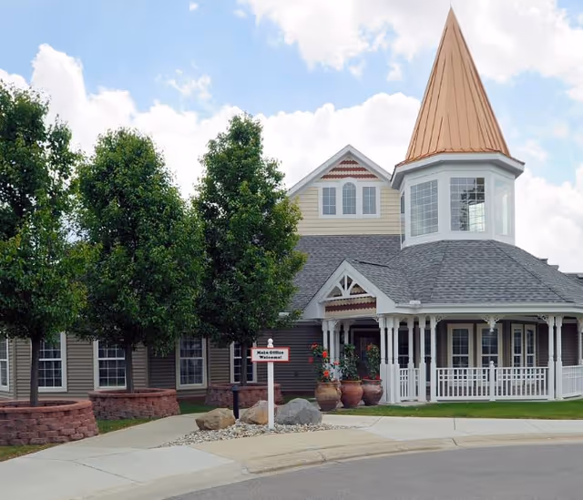 Front view of Symphony Linden senior living facility with porch, trees, and a tower.