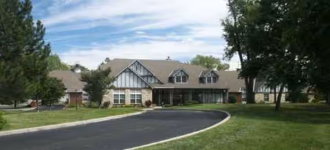 Exterior view of Brookdale Tallgrass, a senior living facility, with curved driveway and trees.