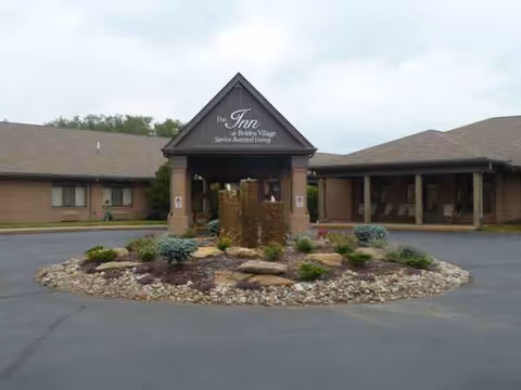 Exterior view of The Inn at Belden Village entrance with landscaped circular island