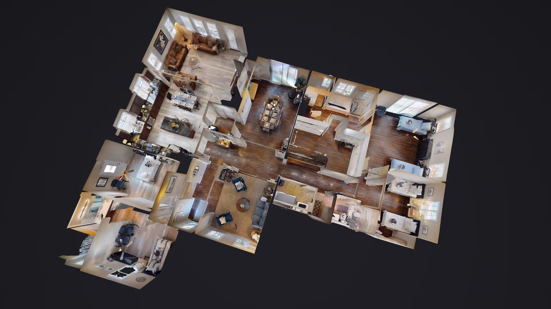 3D floor plan view of an interior living space showing multiple rooms including living rooms with sofas and chairs, dining areas with tables and chairs, bedrooms with beds, and kitchen areas with appliances and counters.