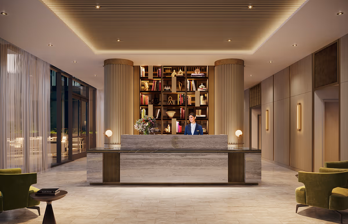 A modern reception area with a large marble desk and a receptionist standing behind it. The background features a tall bookshelf with decorative items and books, flanked by two large cylindrical columns. The room has a high ceiling with recessed lighting and a slatted design. On the left side, there are large windows with sheer curtains, and on the right, wooden panel walls with vertical light fixtures. Two green armchairs and a small round table with books are visible in the foreground.