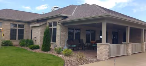 Exterior view of Field of Dreams Assisted Living with a covered front porch and seating.