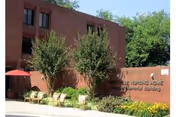 Exterior view of Sterling Care Rockville Nursing with outdoor seating and a brick wall.