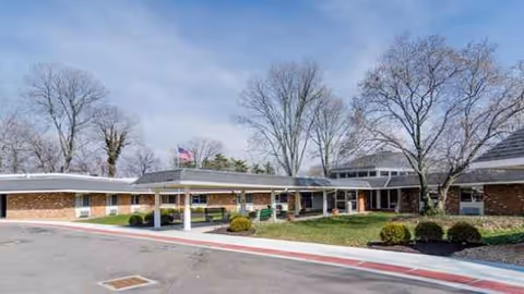 Exterior view of Buckeye Forest at Madeira with brick building, canopies, and trees.